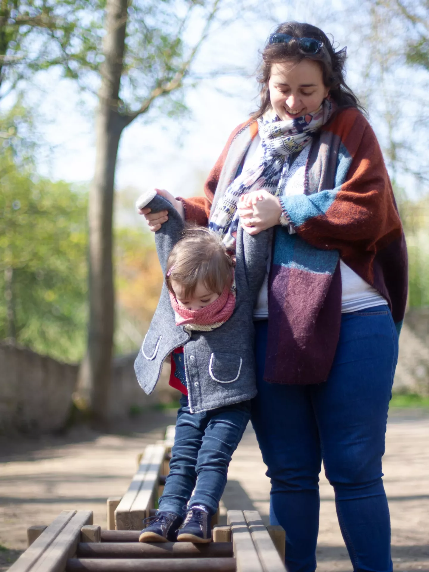 Un photographe de famille à Beziers photographie de façon lifestyle une mère et sa fille jouant dans un parc